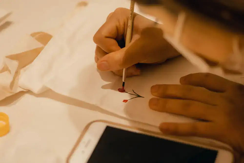Artist carefully painting fine details on a leaf
