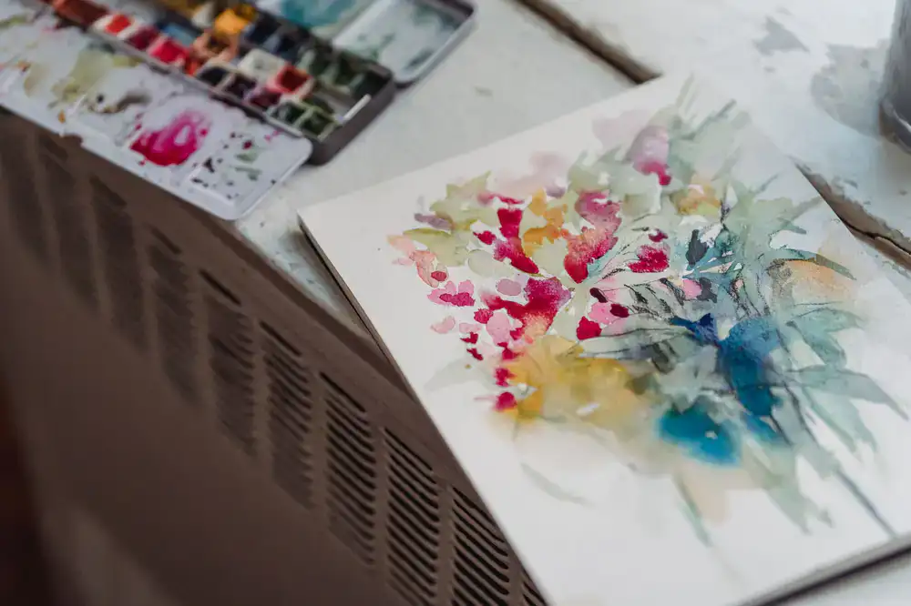 A large bespoke botanical watercolor resting on a wooden drafting table