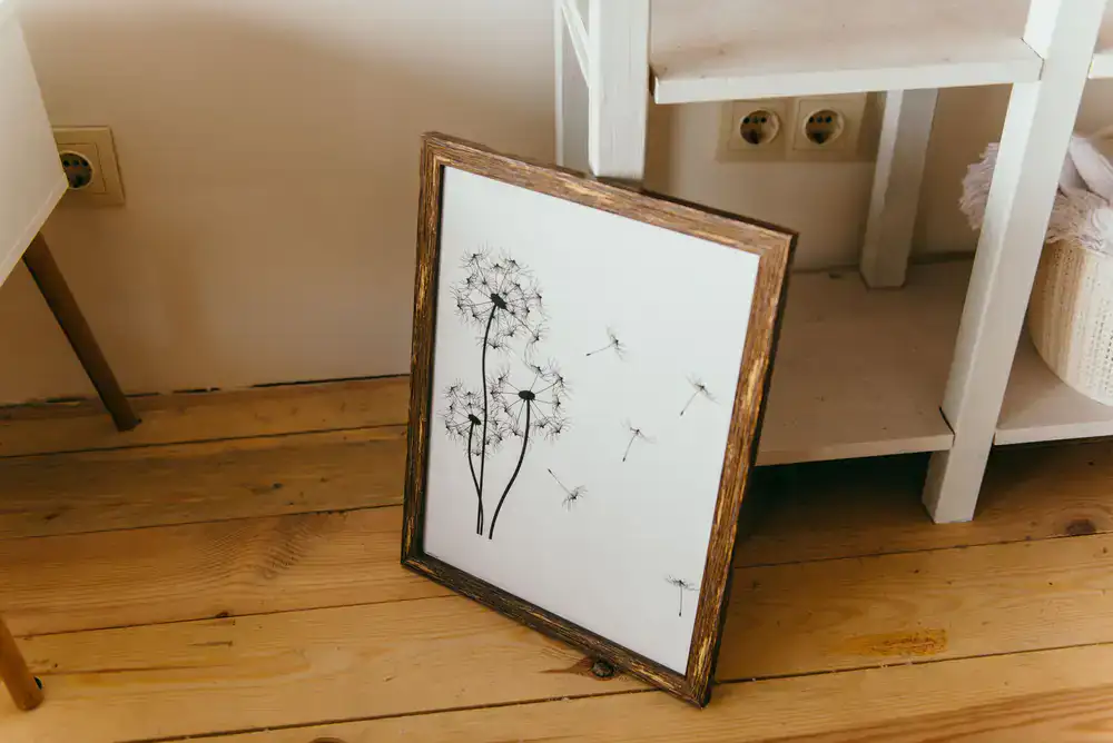 Framed botanical print resting on a wooden shelf